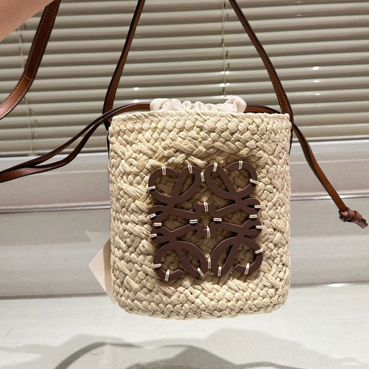 L*E ANAGRAM MINI 18 BUCKET BAG IN NATURAL RAFFIA